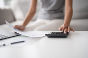 Asian Woman Pressing calculator for financial planner remotely
